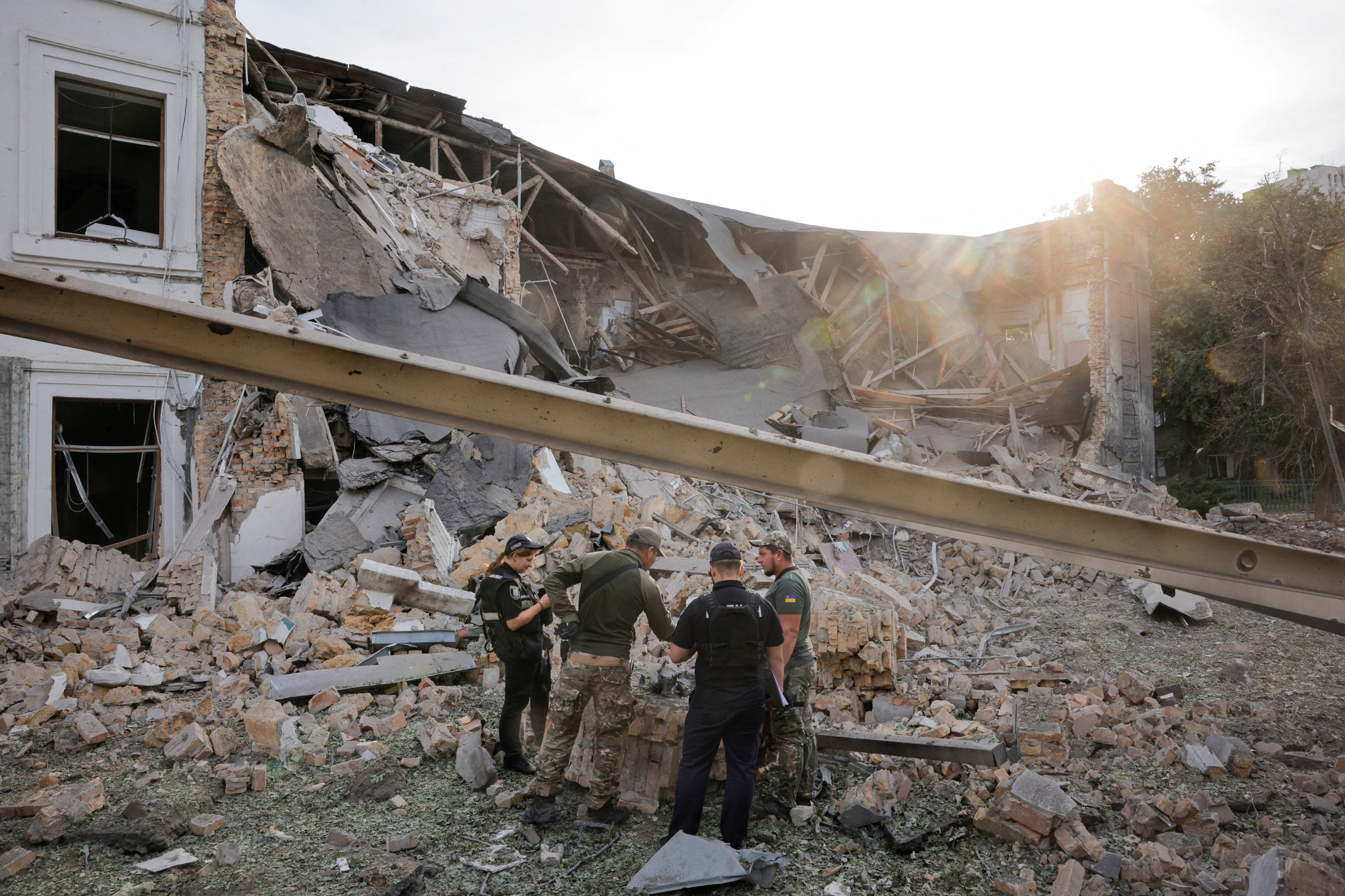 Investigators inspect the site of the Russian missile strike, in Kyiv