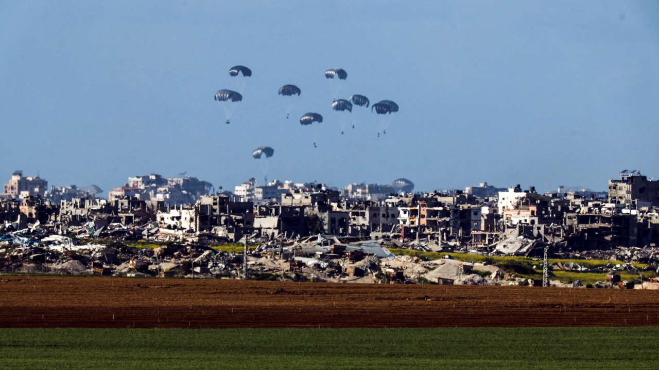 FILE PHOTO: Packages dropped from a military aircraft fall towards northern Gaza, as seen from Israel