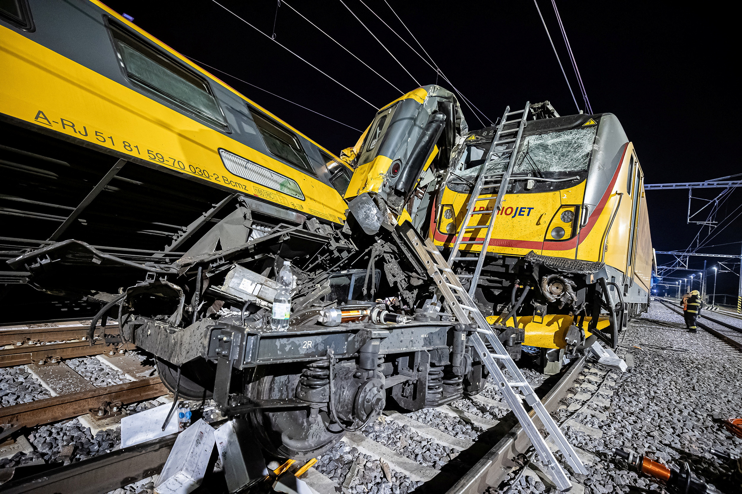 Firefighters work at the scene of a train crash in Pardubice