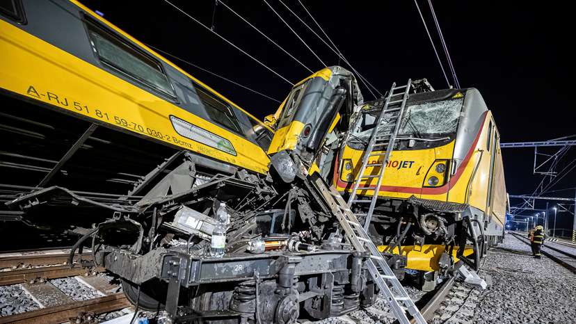Firefighters work at the scene of a train crash in Pardubice