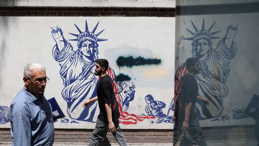 FILE PHOTO: People walk past an anti-U.S. mural on a street in Tehran