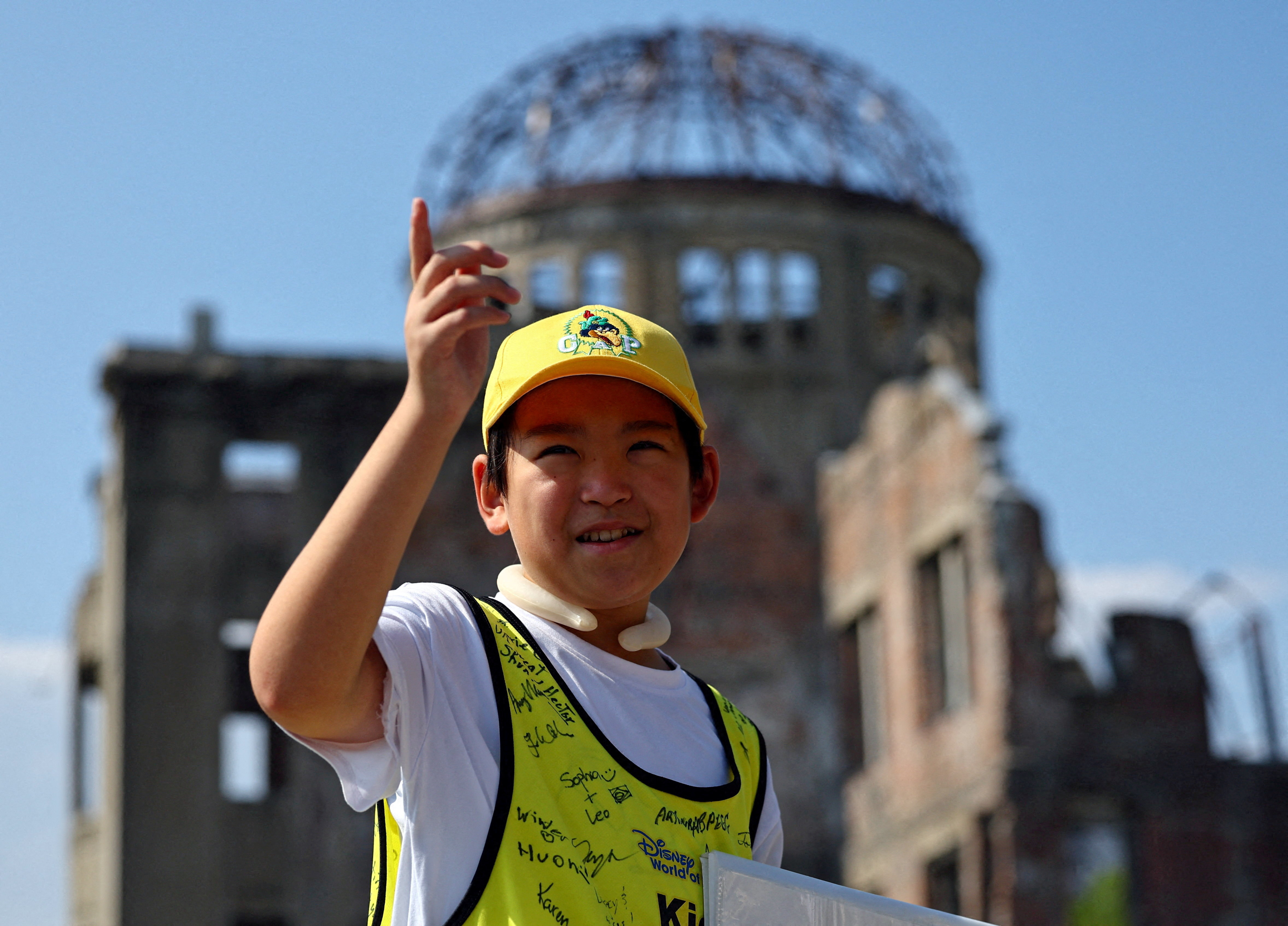 Shun Sasaki, an elementary school student in Hiroshima, guides foreign visitors in front of the Atomic Bomb Dome in Hiroshima