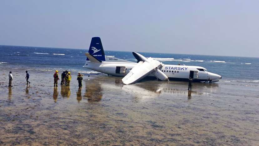 Rescuers stand near a plane that crashed on the seashore in Mogadishu