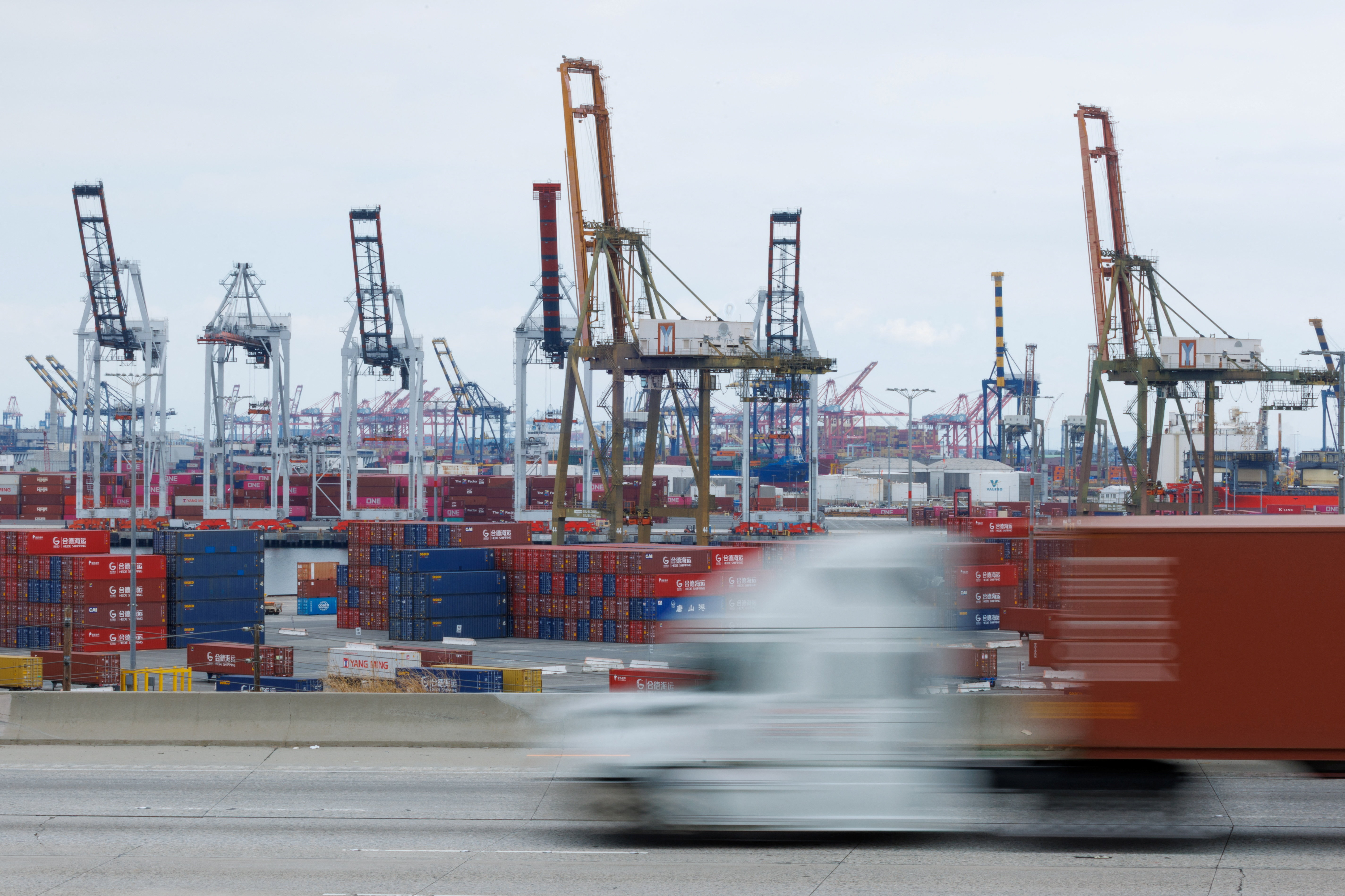 Semi-truck drives past Chinese shipping containers at the Port of Los Angeles