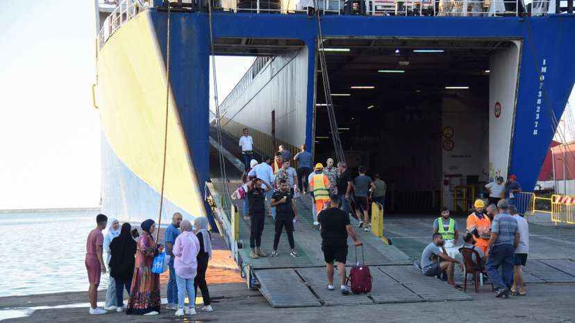 People wait at the port to board a ferry heading to Turkey, in Tripoli