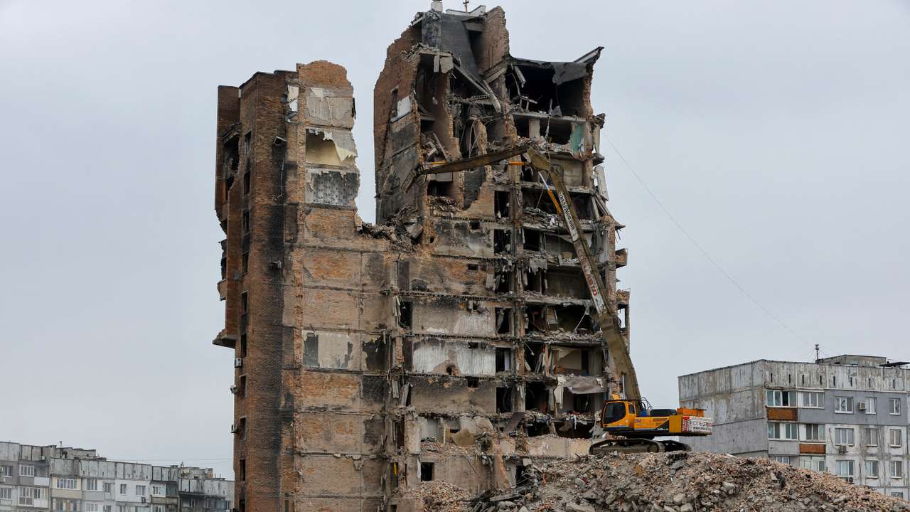FILE PHOTO: An excavator demolishes a multi-storey apartment block in Mariupol