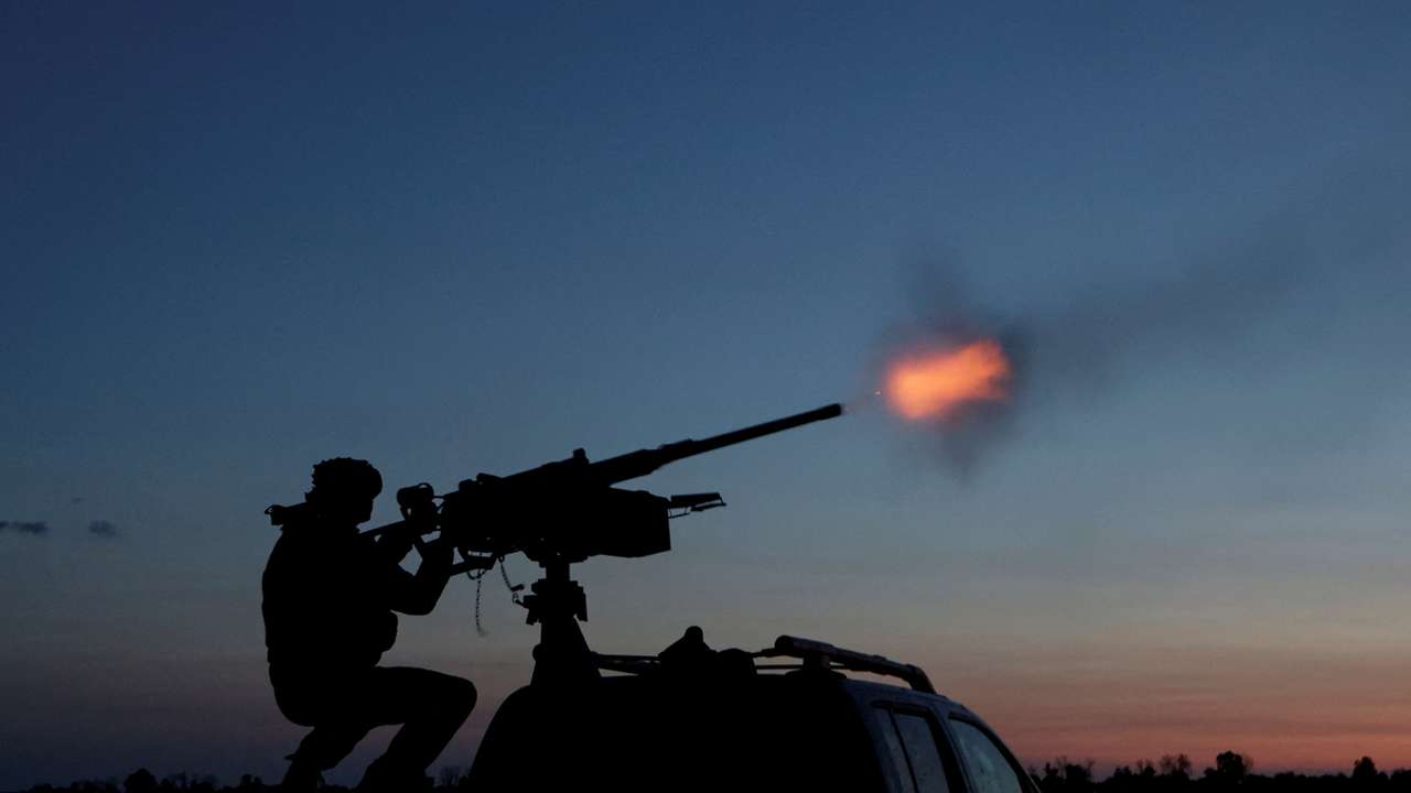 Ukrainian serviceman from mobile air defence unit fires a machine gun towards a Russian drone in Kharkiv region