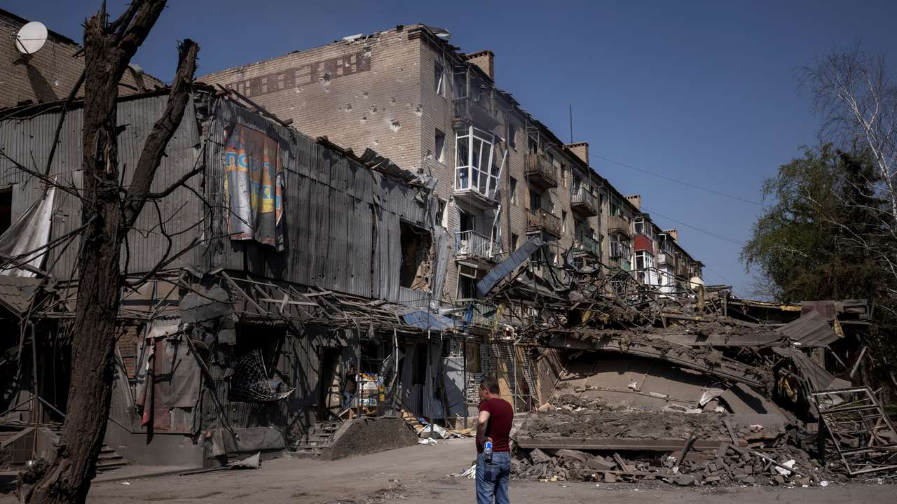 A man looks at the damage from shelling opposite the train station in Kostiantynivka