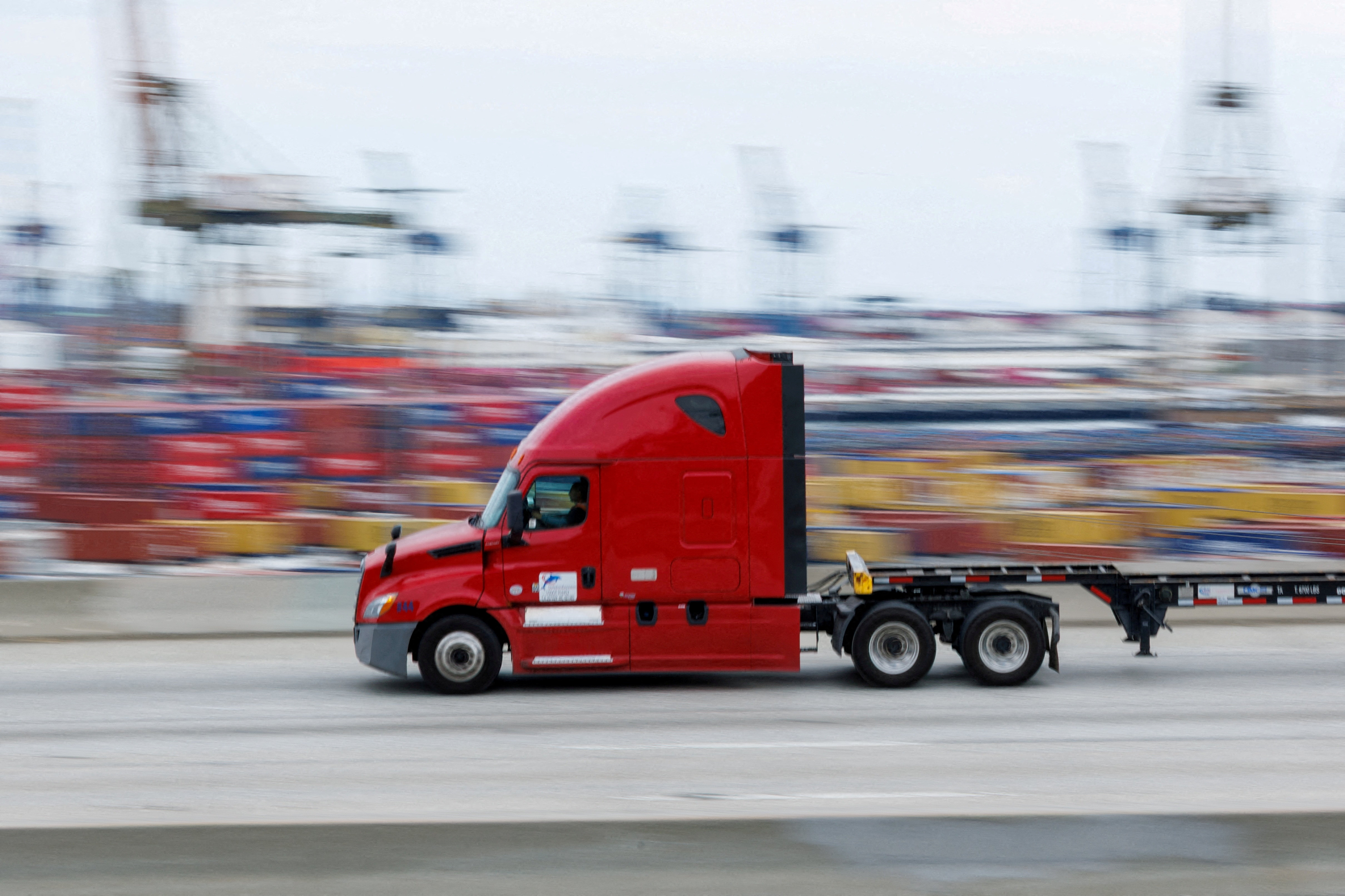 FILE PHOTO: FILE PHOTO: Semi-truck drives past Chinese shipping containers at the  Port of Los Angeles