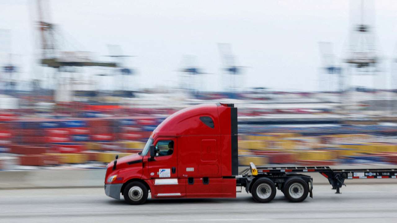 FILE PHOTO: FILE PHOTO: Semi-truck drives past Chinese shipping containers at the Port of Los Angeles