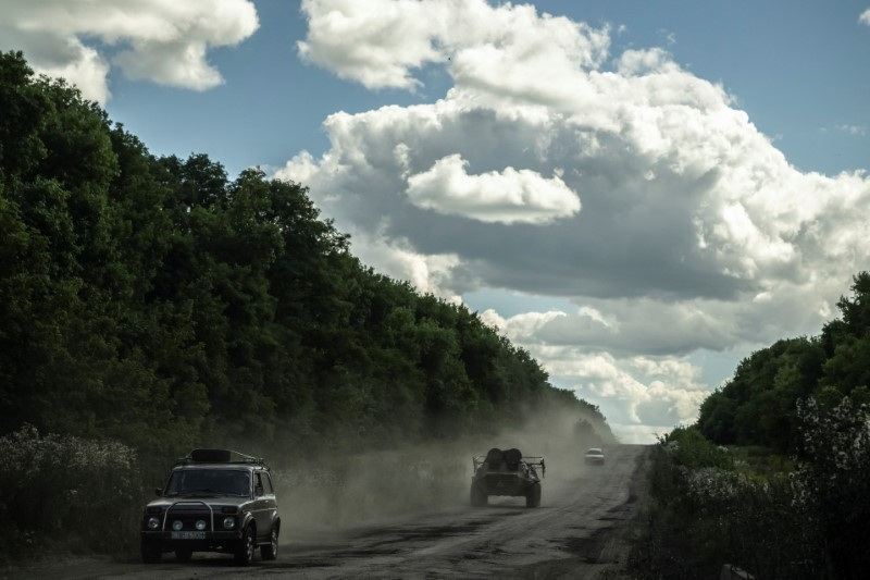 Ukrainian service members ride an Armoured Personnel Carrier near the Russian border in Sumy region