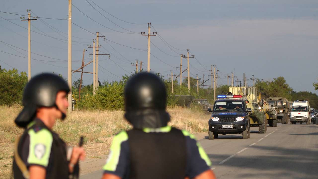 Law enforcement officers drive along a road following the seizure of hostages by a group of inmates in a penal colony in Surovikino