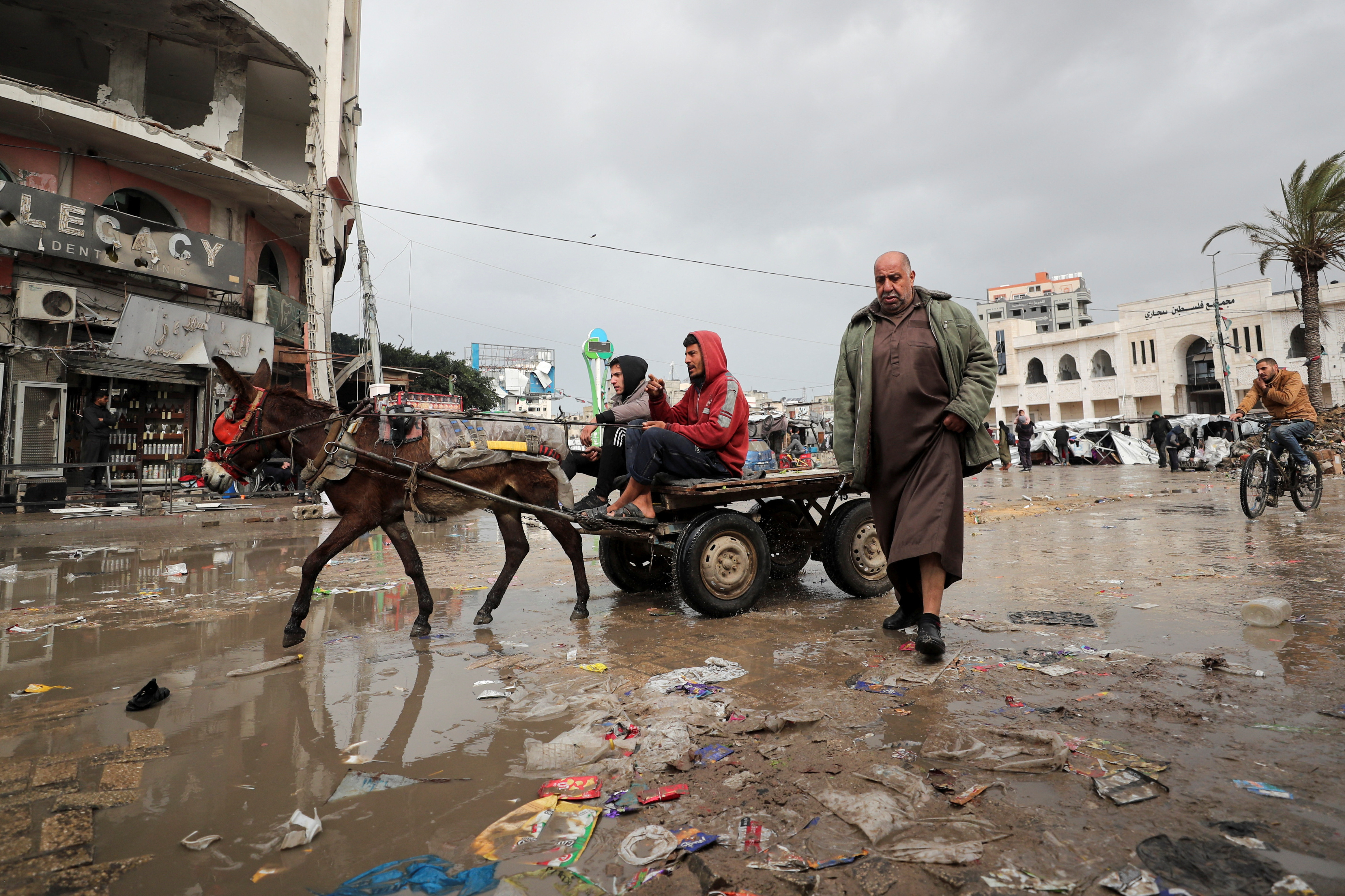 Palestinians make their way along a road on a rainy day, amid a ceasefire between Israel and Hamas, in Gaza City