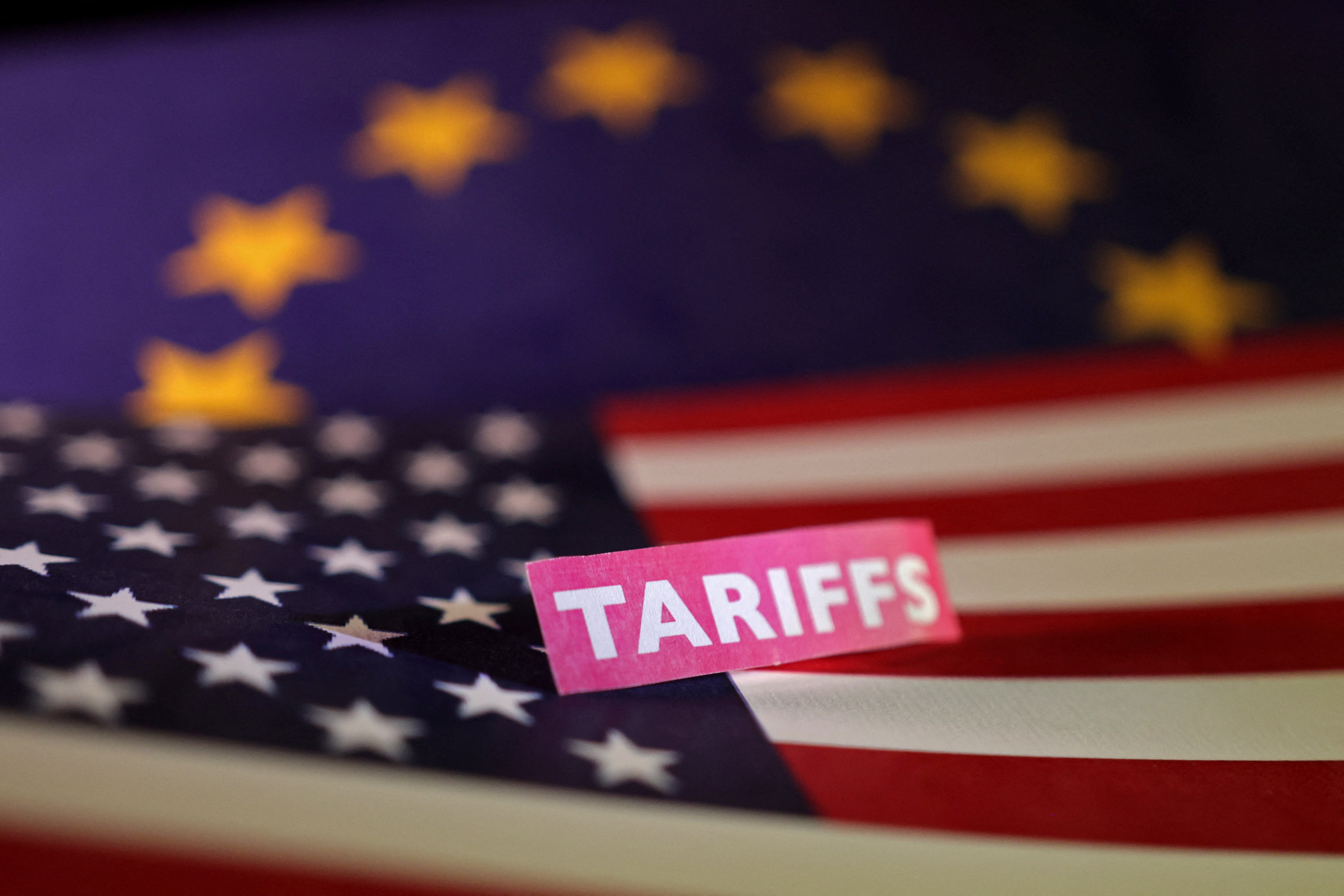 Illustration shows U.S. and European Union flags and "tariffs" label