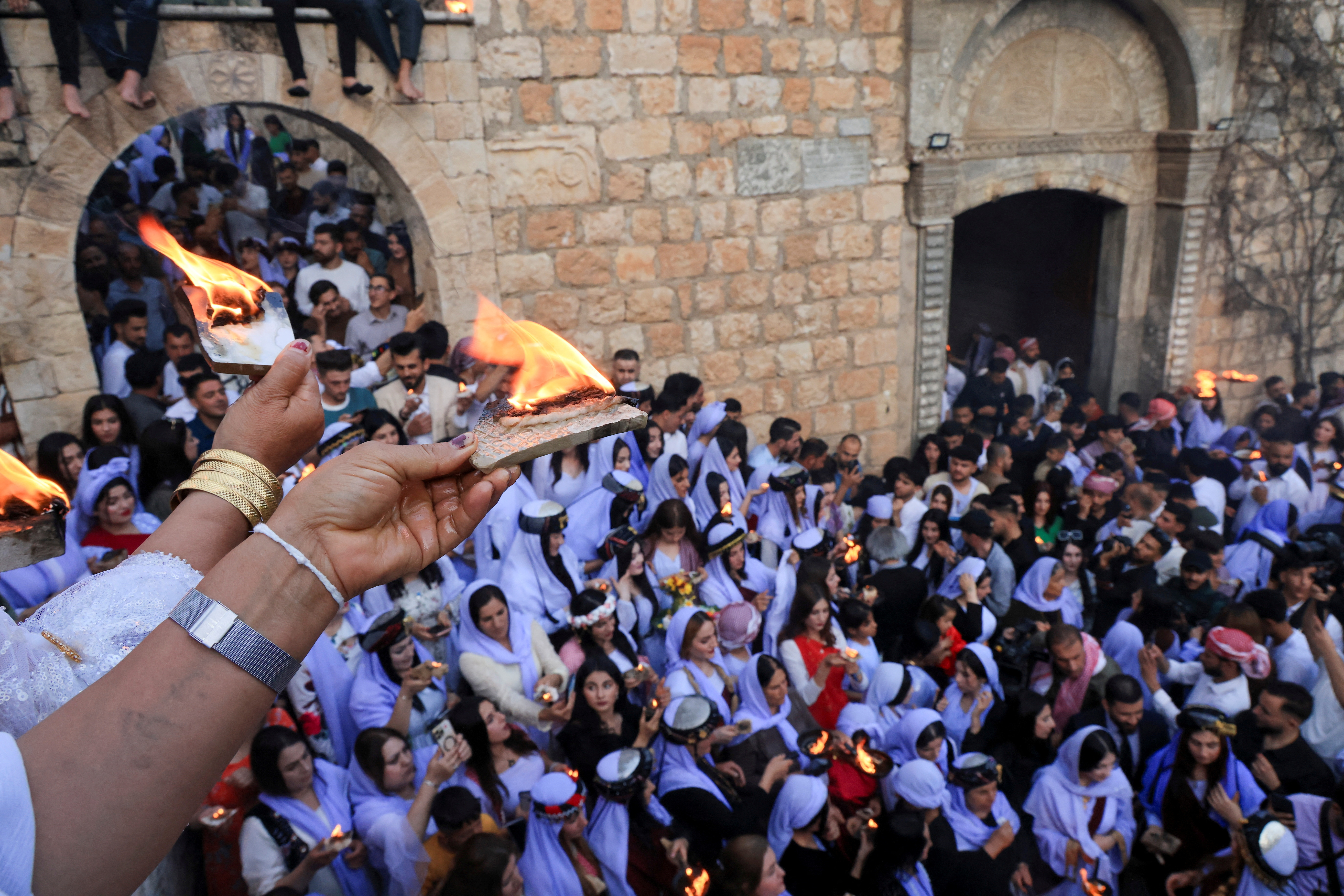FILE PHOTO: Iraqi Yazidi women light candles on the occasion of Red Wednesday, a ceremony to celebrate the Yazidi New Year at Lalish temple in Shekhan District in Duhok province