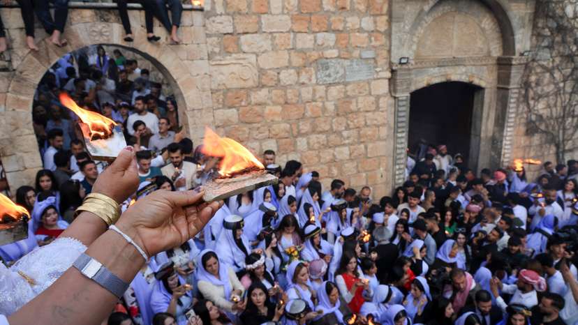 FILE PHOTO: Iraqi Yazidi women light candles on the occasion of Red Wednesday, a ceremony to celebrate the Yazidi New Year at Lalish temple in Shekhan District in Duhok province