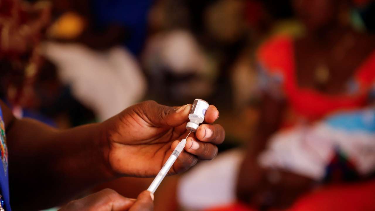 A nurse prepares to administer a malaria vaccine to an infant at the health center in Datcheka