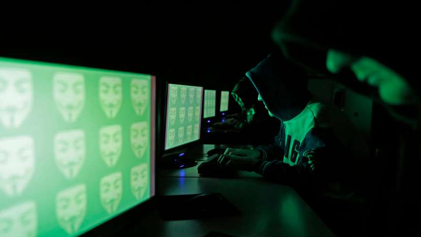 People pose in front of a display showing the word 'cyber' in binary code, in this picture illustration taken in Zenica