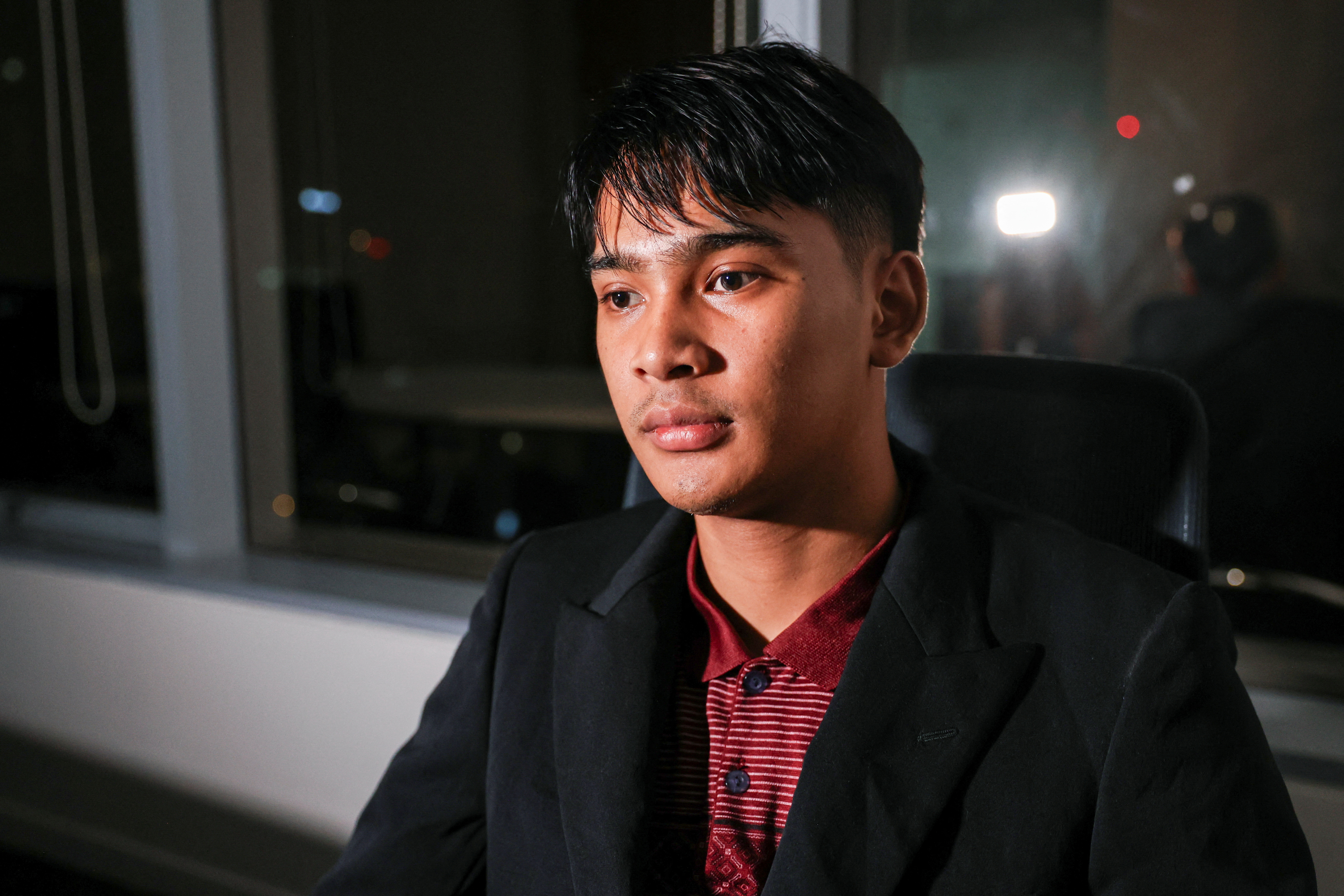 Louis, a Thai victim of scam centers who was trafficked into working in Cambodia, looks on during an interview with Reuters, in Bangkok