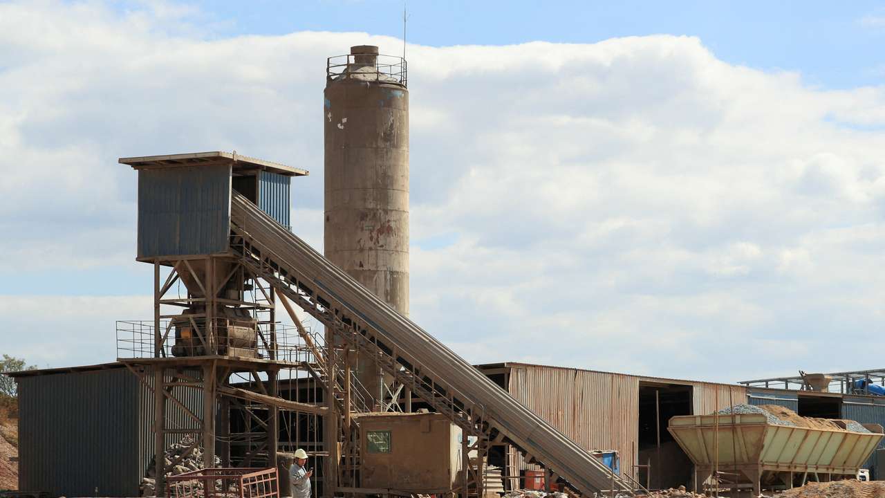 FILE PHOTO: A worker checks their mobile phone at Prospect Lithium mine and processing plant in Goromonzi