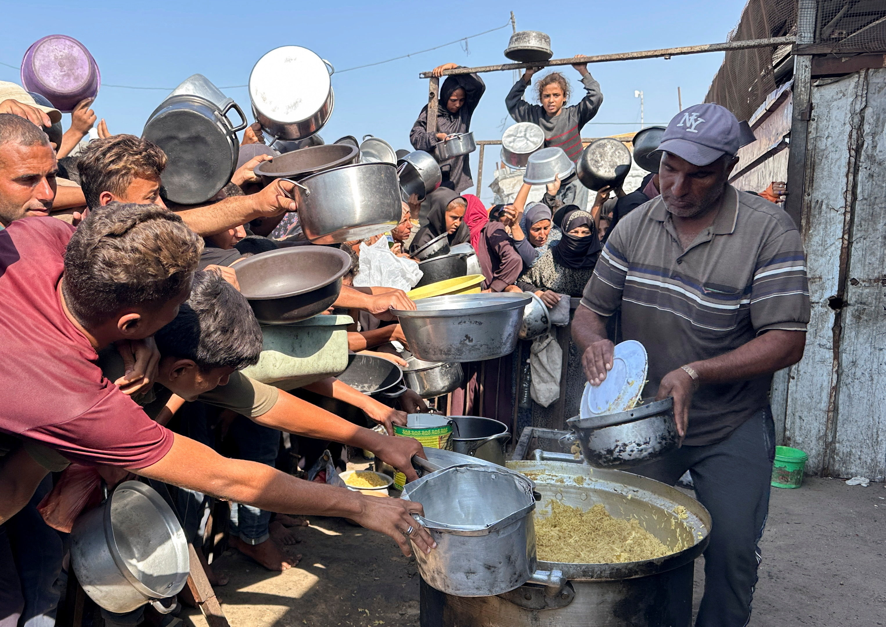Palestinians gather to receive food from a charity kitchen amid a ceasefire between Israel and Hamas, in Khan Younis