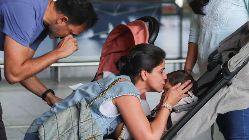 A mother kisses her child after they returned from Dubai amid the U.S.-Israel conflict with Iran, at the Chhatrapati Shivaji Maharaj International Airport in Mumbai