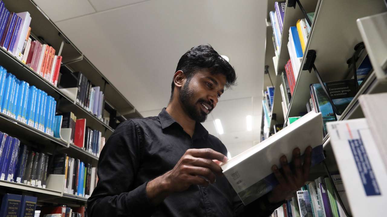 Prathesh Panjak, a first time immigrant voter, reads a book at a library, ahead of Britain's general election, in Manchester