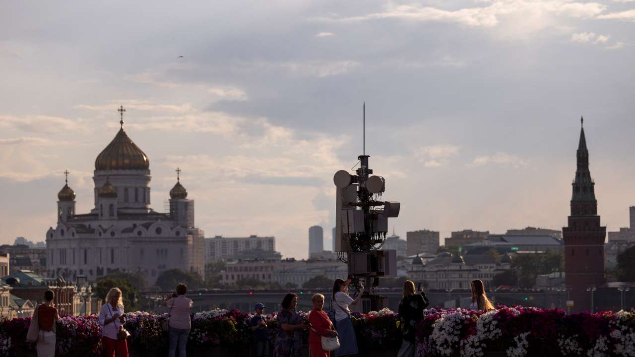 People gather on a bridge with the view on Christ the Savior Cathedral, in Moscow