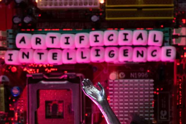 Illustration shows AI (Artificial Intelligence) letters and robot hand