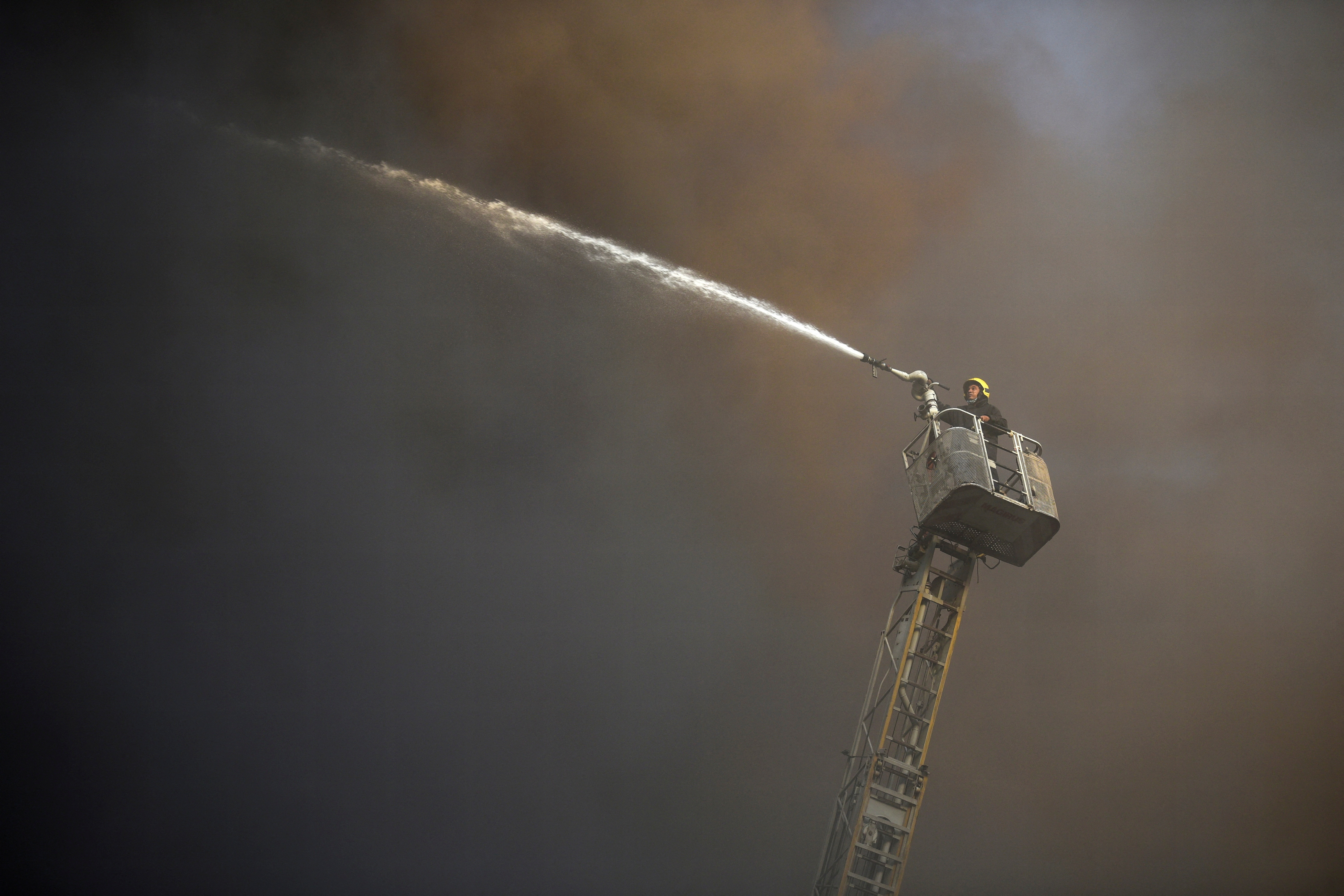 A firefighter tries to put off a fire that broke out in a telecommunications building in Cairo