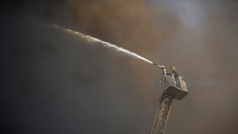 A firefighter tries to put off a fire that broke out in a telecommunications building in Cairo