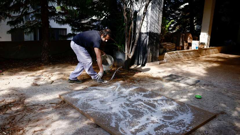 Lebanese artist Charbel Samuel Aoun works on an art piece using dust mixed with resin, in Fanar