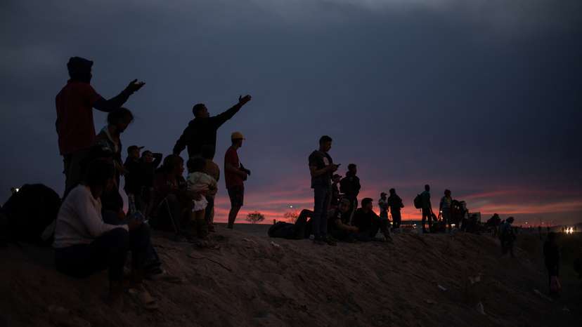 Migrant point towards the United States from the bank of Rio Grande river in Ciudad Juarez