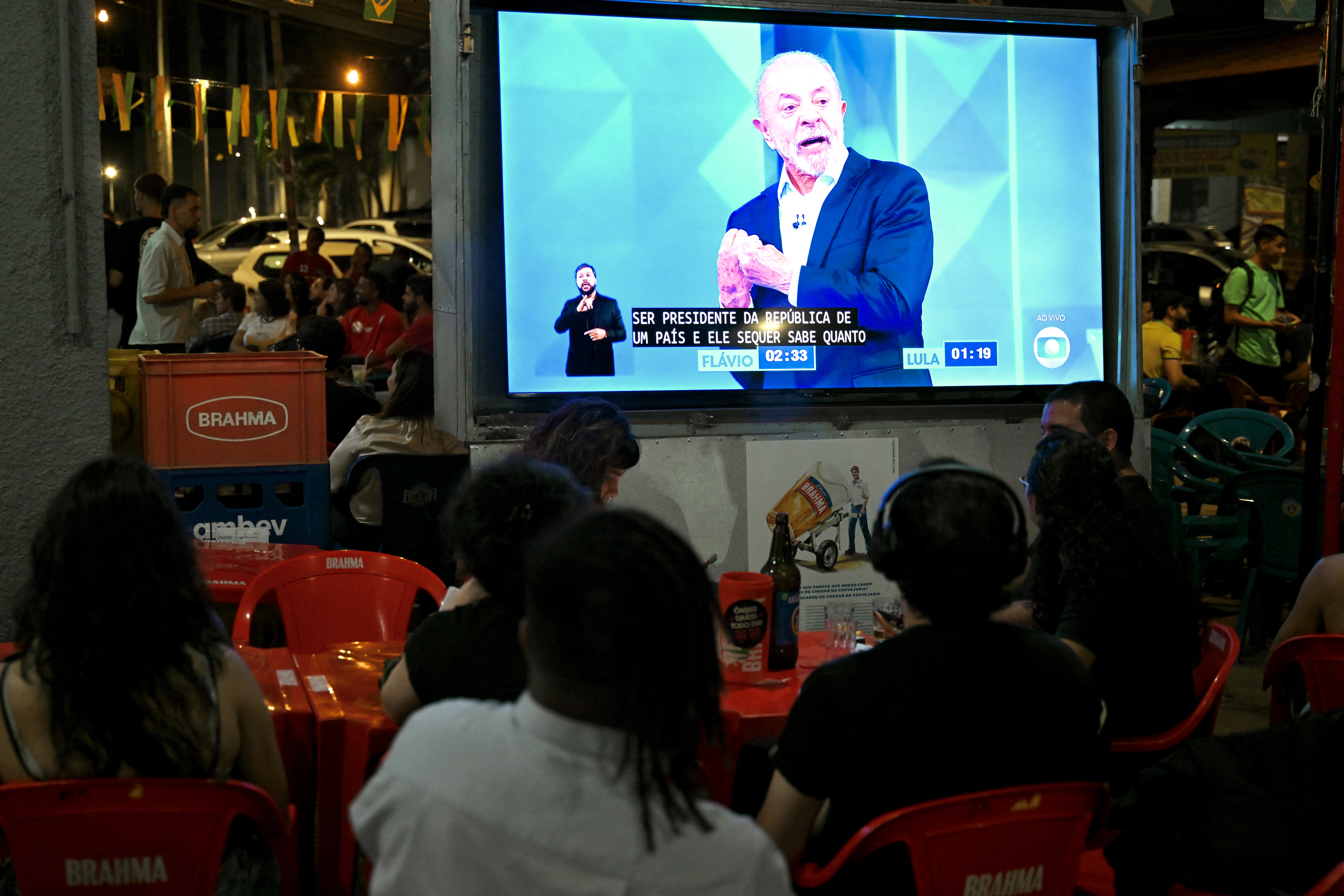 Eleitores acompanham último debate entre o presidente Luiz INácio Lula da Silva e Flavio Bolsonaro, em 23 de outubro de 2026. (Foto de Evaristo Sa / AFP)