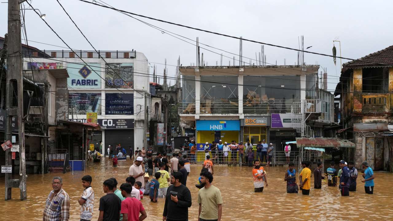 People gather at an area affected by floods, following heavy rainfall in Malwana