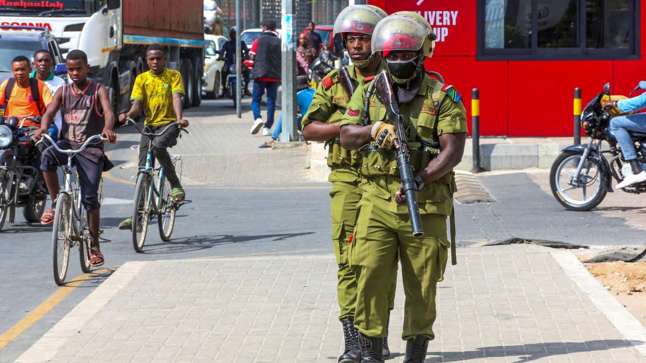 Tanzania riot police officers walk during the protests to condemn a series of kidnappings and murders in Dar es Salaam