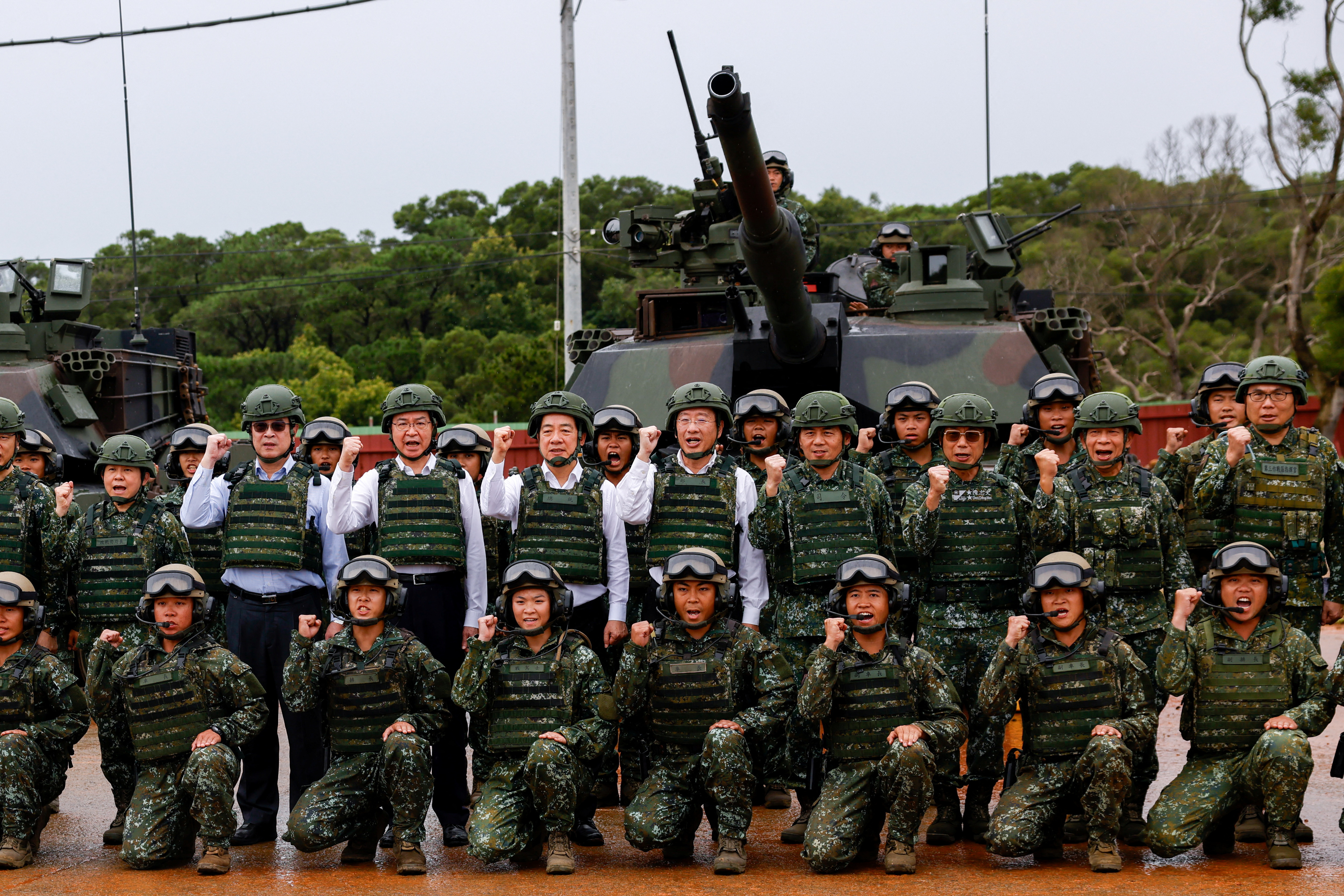 Taiwan's President Lai Ching-te poses for a group photo in front of U.S.-made M1A2T Abrams tanks after taking part in live-fire exercises in Hsinchu