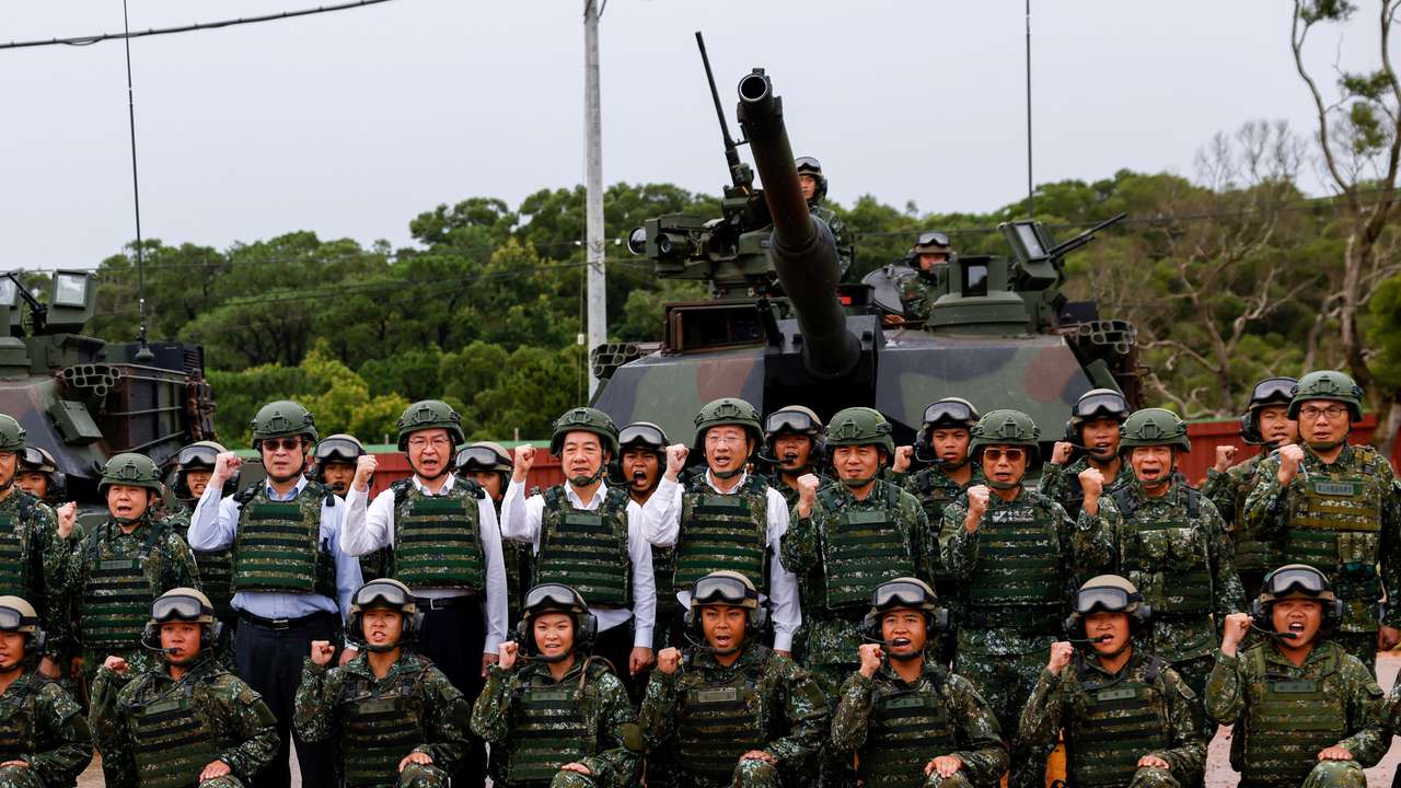 Taiwan's President Lai Ching-te poses for a group photo in front of U.S.-made M1A2T Abrams tanks after taking part in live-fire exercises in Hsinchu