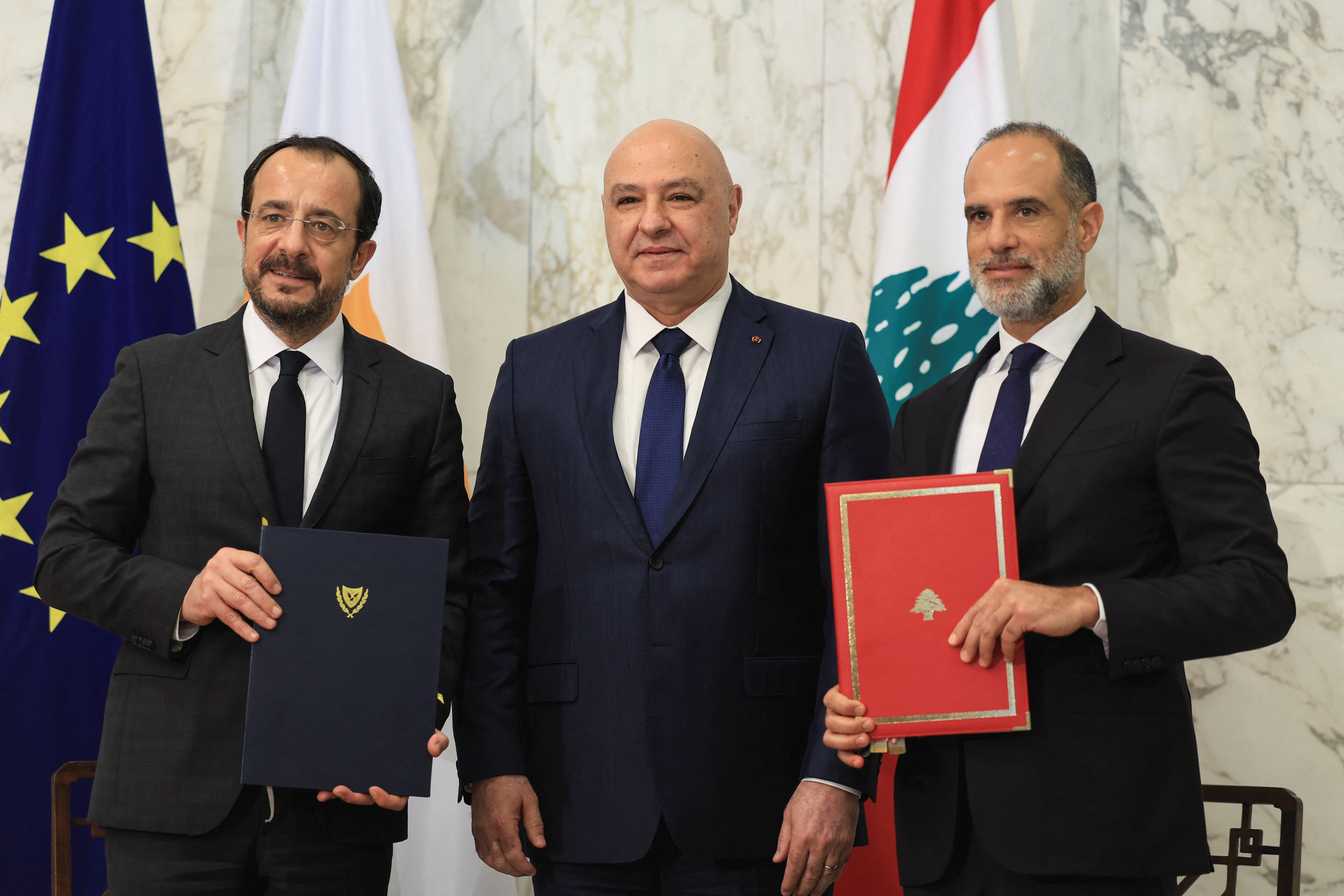 Cyprus' President Nikos Christodoulides and Fayez Rasamny, Lebanese Minister of Public Works and Transport, hold the maritime demarcation agreement documents after signing it, at the presidential palace in Baabda