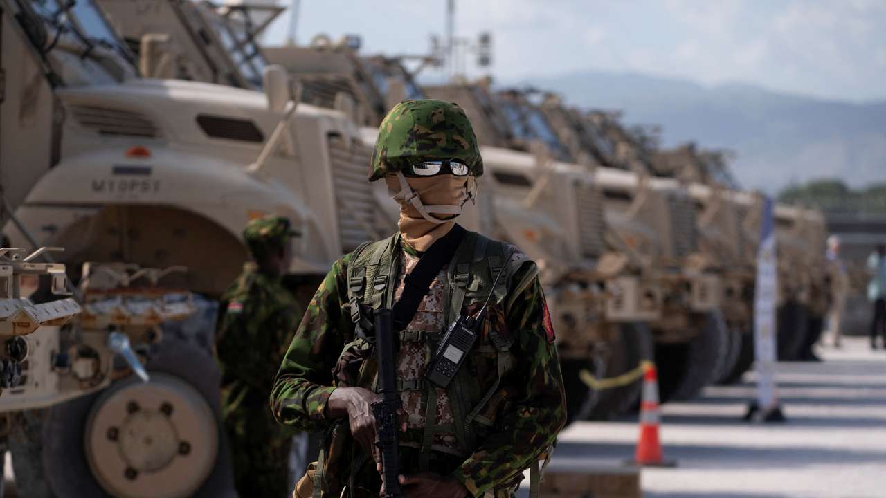 FILE PHOTO: A Kenyan police officer stands next to a row of anti-mine armoured vehicles in Port-au-Prince, Haiti
