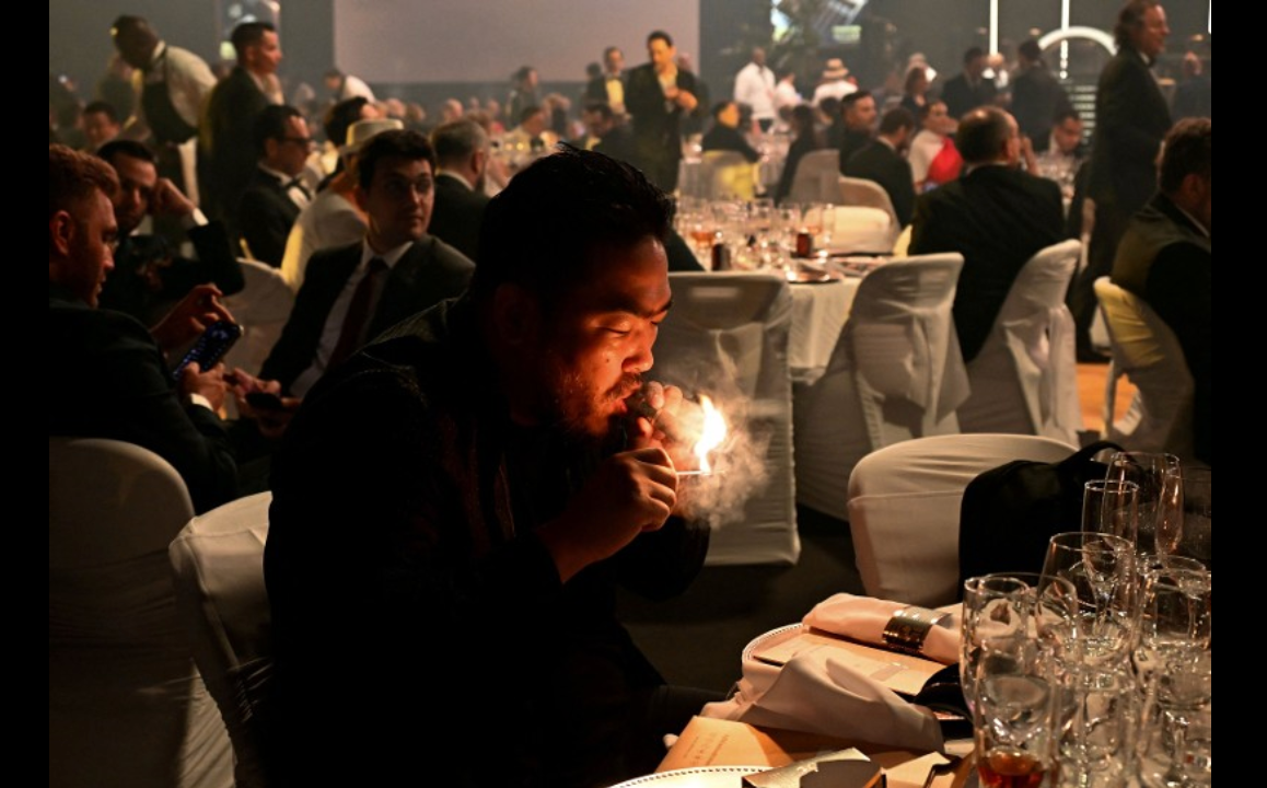 A man smokes a cigar during a humidor auction held as part of the closing ceremony of the XXV Habanos Festival in Havana