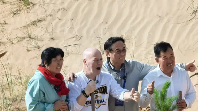 Yin Yuzhen (left) and Ronald Salkolsky (second left) planting trees in the desert.