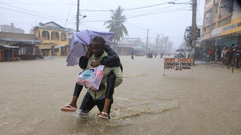 A man wades through flood waters along a street following heavy rains in Kisauni district of Mombasa