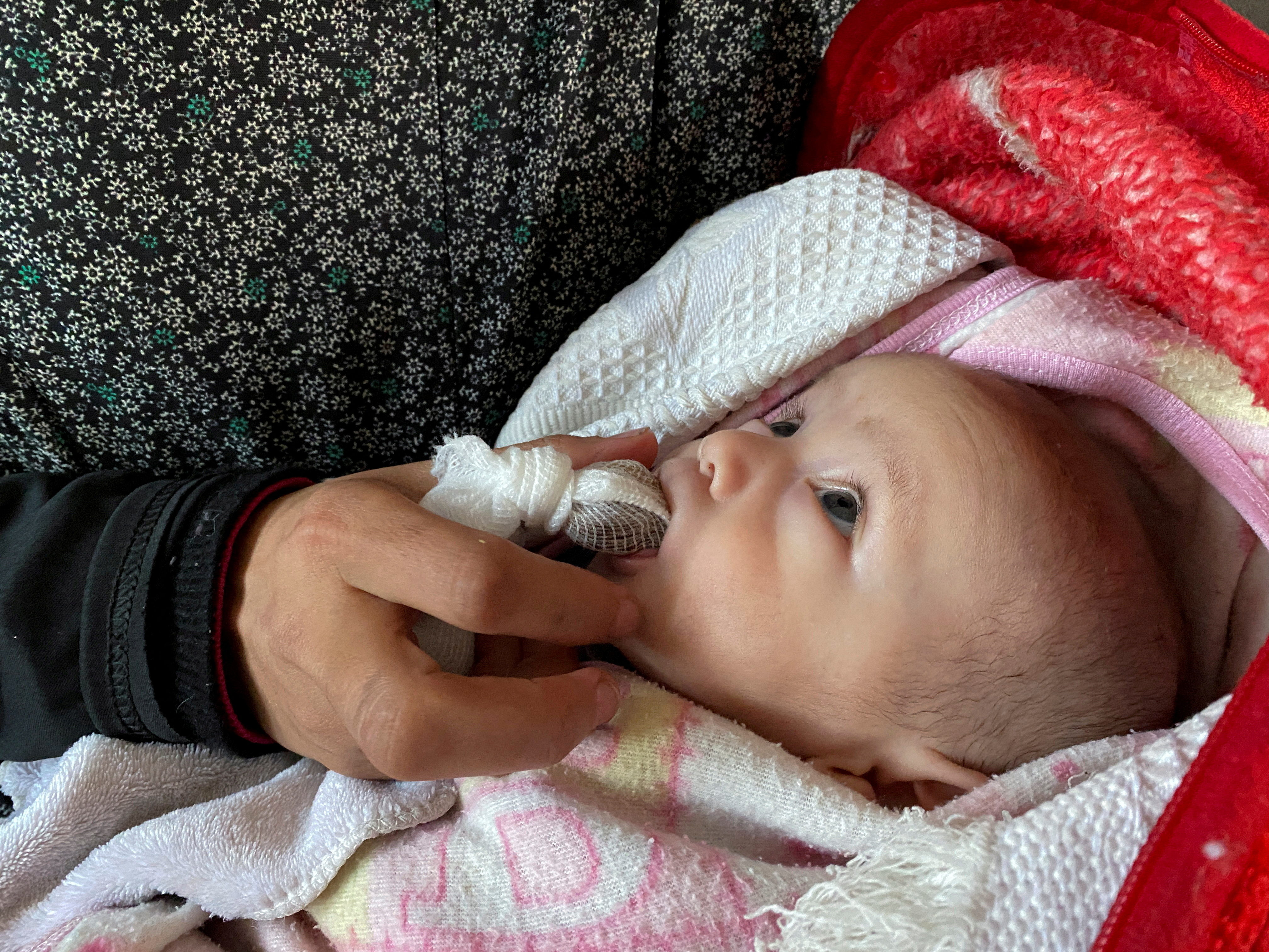Palestinian woman Mattar feeds her newborn dates instead of milk amidst food scarcity in Nuseirat, Gaza Strip