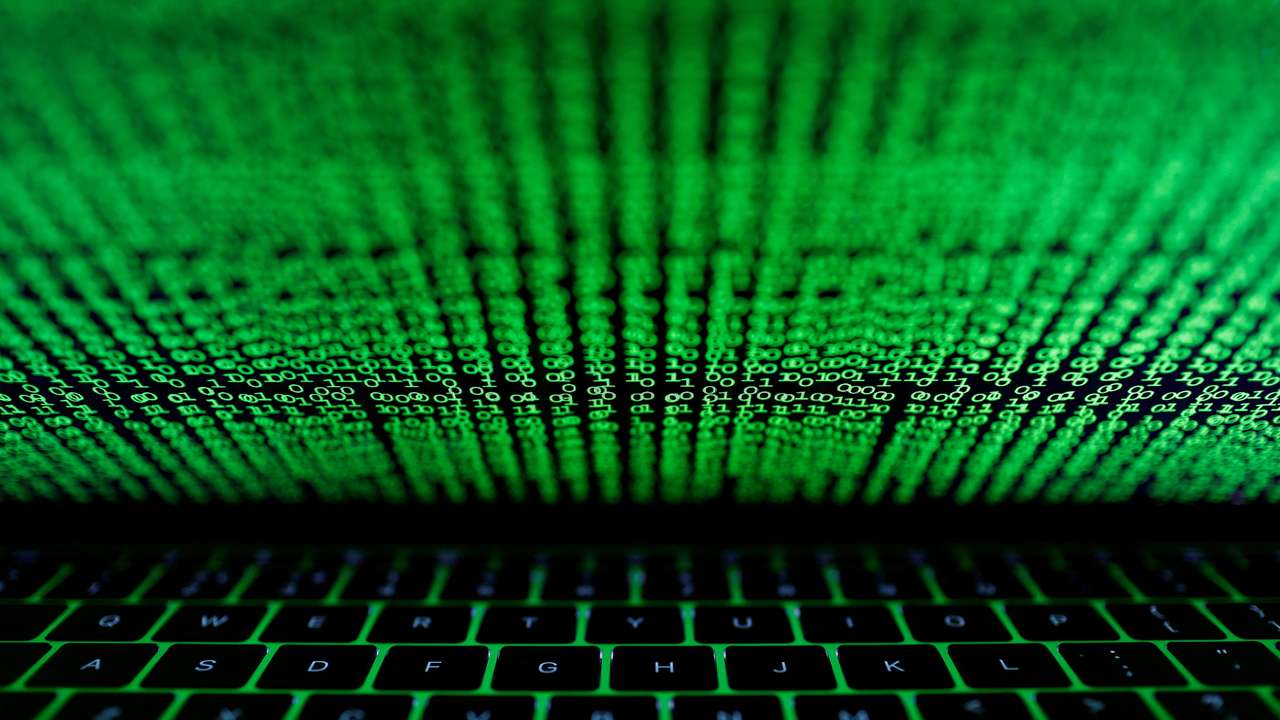 A computer keyboard lit by a displayed cyber code is seen in this illustration picture