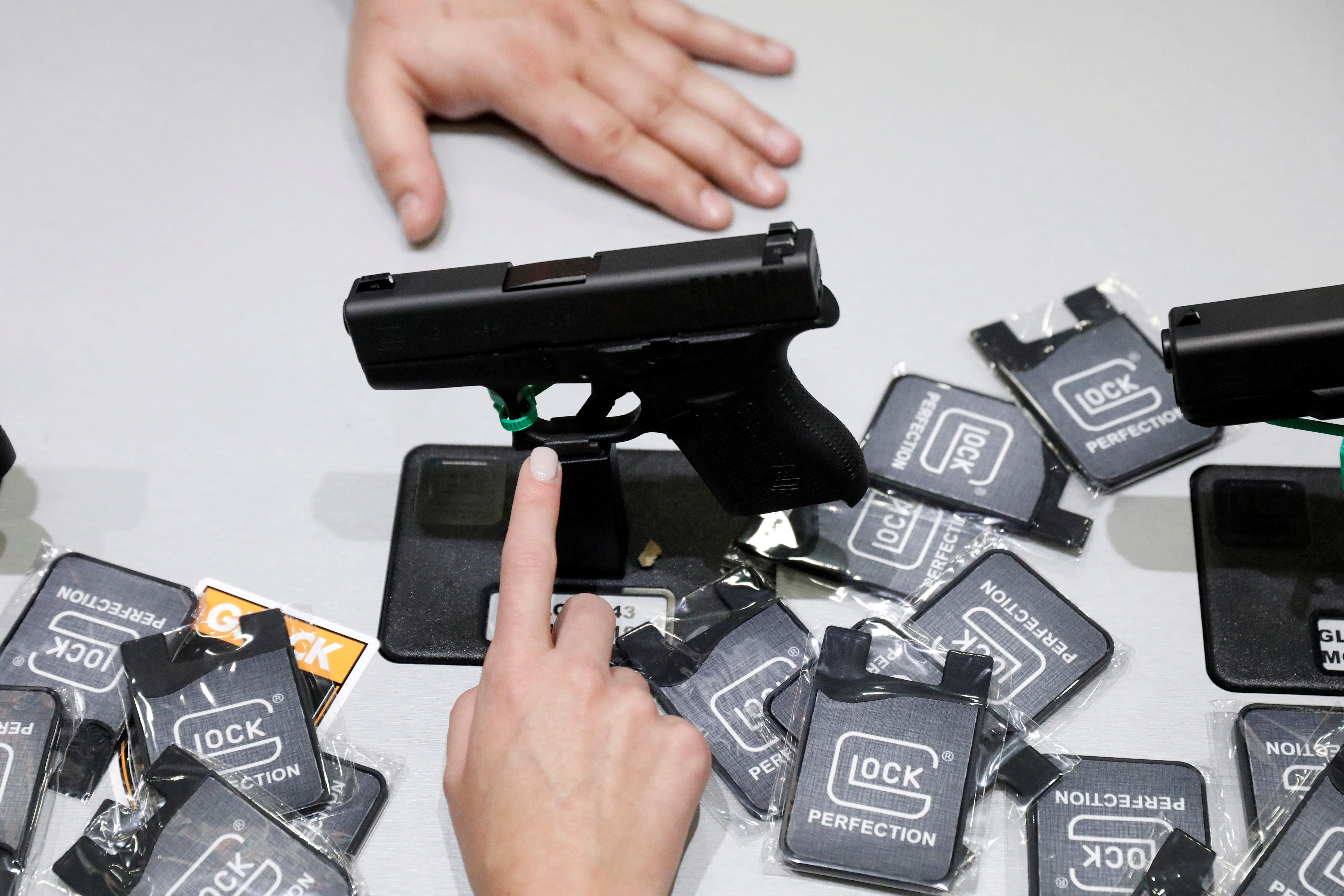 FILE PHOTO: A woman points at a Glock handgun during the annual National Rifle Association (NRA) convention in Dallas, Texas