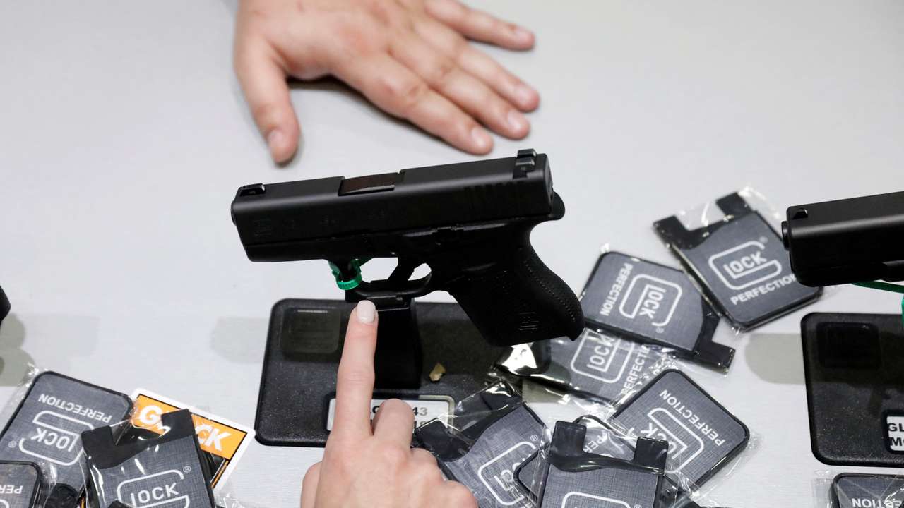 FILE PHOTO: A woman points at a Glock handgun during the annual National Rifle Association (NRA) convention in Dallas, Texas