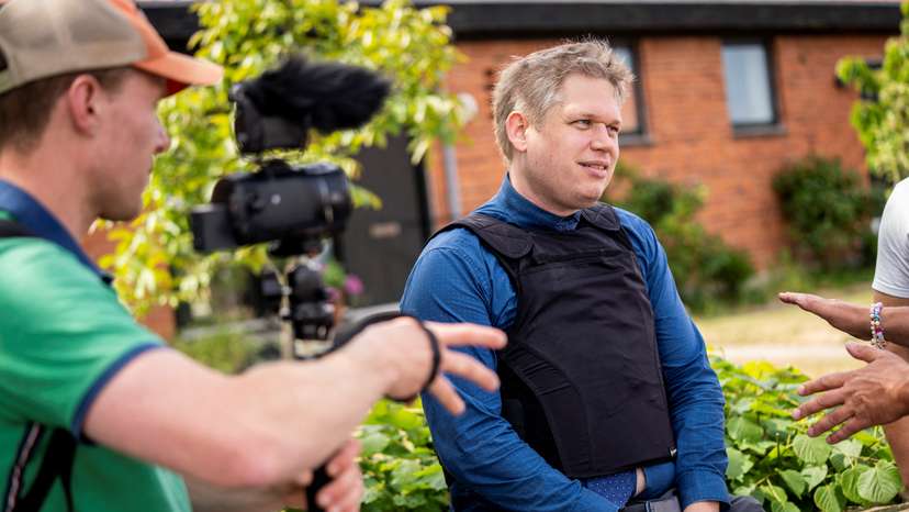 Far-right politician Rasmus Paludan sits outside the prohibition zone as he is being ordered by the police to not participate in the Folkemodet festival in Allinge