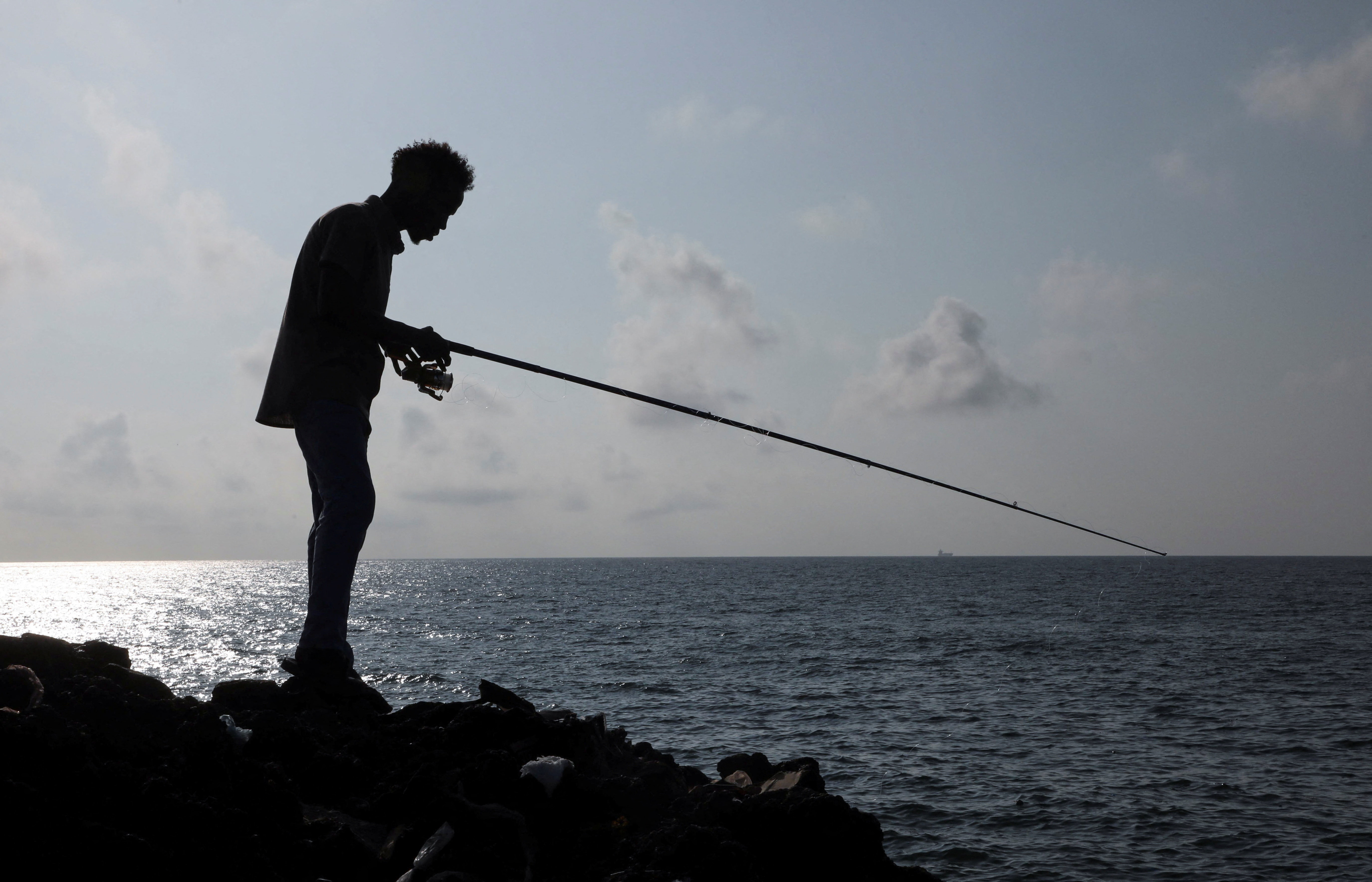A man fishes in the Indian Ocean waters in Hamarweyne district of Mogadishu