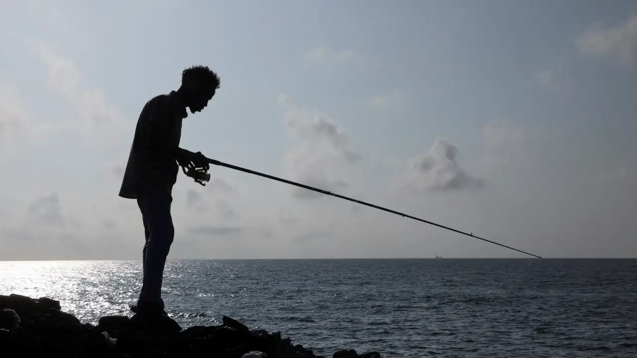 A man fishes in the Indian Ocean waters in Hamarweyne district of Mogadishu